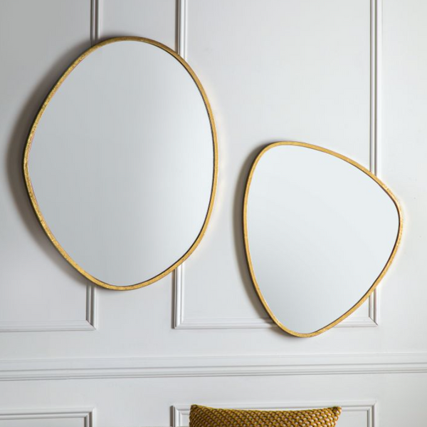 Two organic freeform gold edge mirrors on the wall, one large mirror, one small