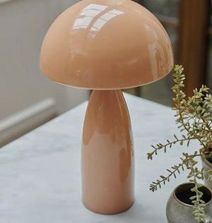 Blush domed table lamp, not lit sitting on a marble table