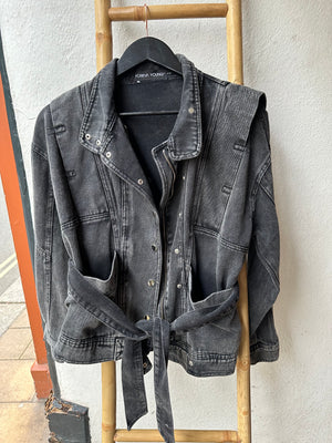 Faded Black denim jacket with 80s design lapels, belt done up on jacket which is displayed on a ladder