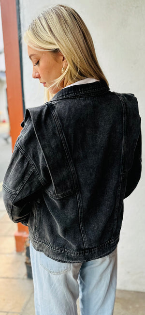 model wears a Faded Black denim jacket with 80s design lapels - model has back to camera so can see the back of the jacket