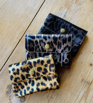 3 Leather Leopard  print coin purse on wooden surface in gold, black and bronze print