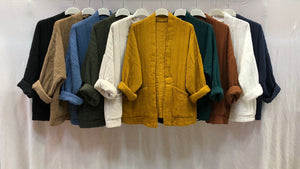 10 quilted jackets hung from the ceiling in black, brown, blue, cream, yellow, dark green, bronze, white and grey