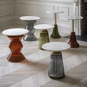 Six Bilbao Side Tables in a room.  Two high marble top tables with green or orange based.  Three lower side marble top side tables with blue, orange and green glass bases