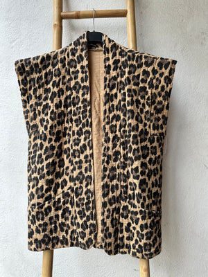 leopard print padded floral  women's gilet on a hanger placed on a wooden ladder against a white background