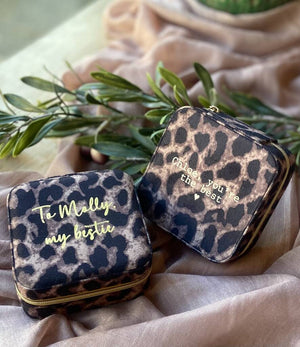 Two leopard print zip jewellery cases sit side by side with gold embossed messages on each one.  