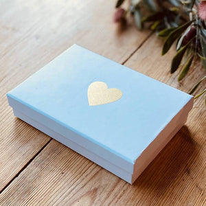 A blue gift box with a gold heart embellished in the centre